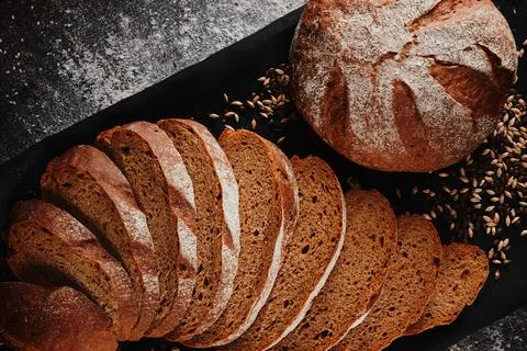 Assortment of baked bread from rye and wheat flour on black background. Top view Stock Photos