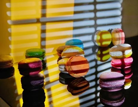 An assortment of bright macarons of different colors is displayed on a glas.. Stock Photos