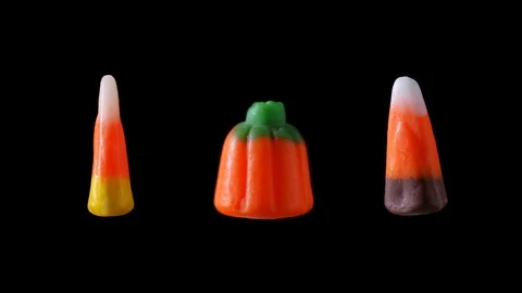 An assortment of candy corn Halloween candy is seen floating and rotating Stock Footage 116399904