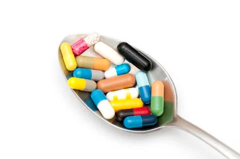 Assortment of capsules in table spoon Stock Photos
