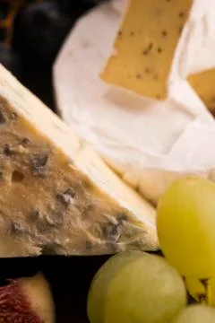 Assortment of cheese with fruits and grapes Stock Photos
