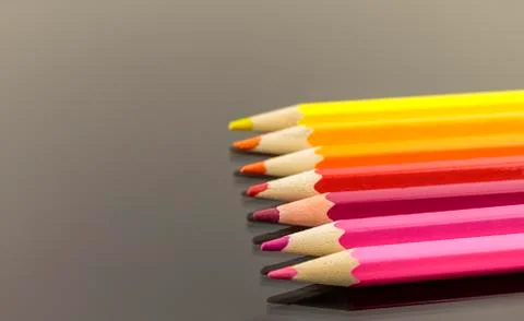 Assortment of colored pencils in a stack in shallow focus on balck background Stock Photos