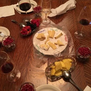 Assortment of Cut Up Fruit, Gourmet Cheeses Plate, Wine - Smörgåsbord Dining Stock Photos