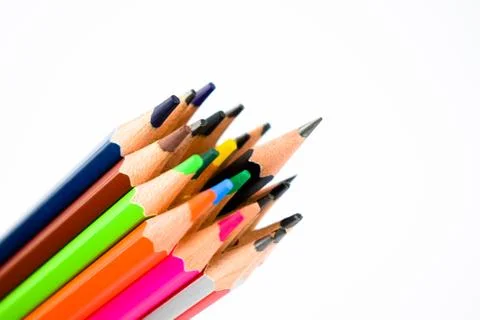 Assortment of different colored pencil crayons pointing up on a white backgro Stock Photos