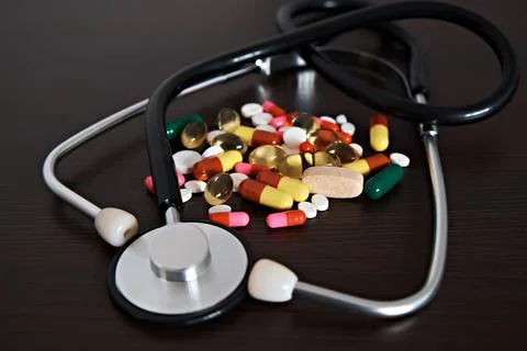 An assortment of different pills and a stethoscope. The topic of health care, Stock Photos