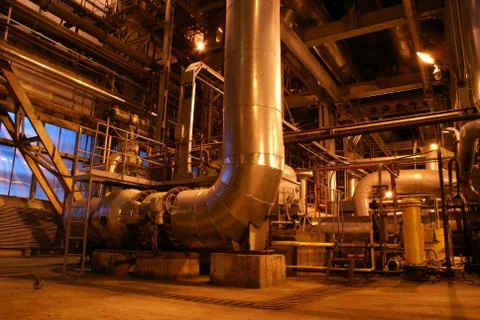 An assortment of different size and shaped pipes at a power plan Stock Photos