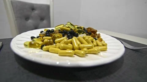 An assortment of different sized pills, vitamins, and supplements on a plate. Stock Footage 290197216