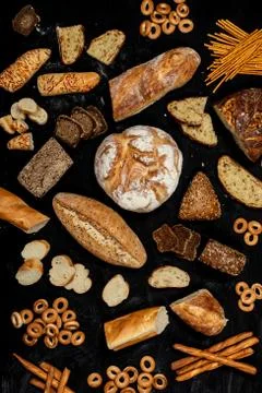 Assortment of different types of bread on a black background. Top view Stock Photos