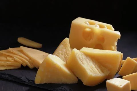 Assortment of different types of cheese on dark background. Cheese background Stock Photos