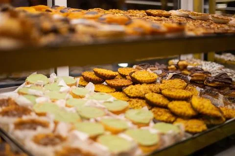 Assortment of different types of cookies on display in a shop window Stock Photos