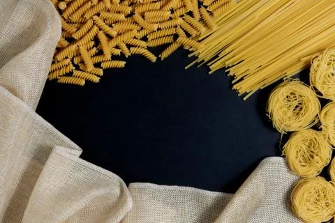 Assortment of different types of pasta dry on black background. Stock Photos
