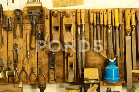 Assortment of do it yourself tools hanging in a wooden cupboard against a wal Stock Photos