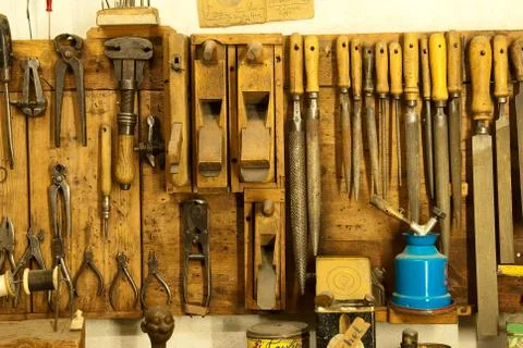 Assortment of do it yourself tools hanging in a wooden cupboard against a wal Stock Photos