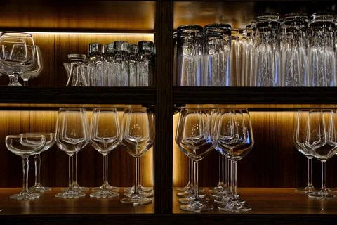 Assortment of Empty Wine Glasses on Rustic Wooden Shelf in Bar. 스톡 사진