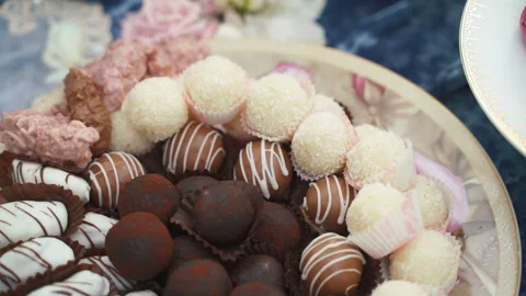 An assortment of fine chocolates in white, dark, and milk chocolate on table Stock Footage 196218139
