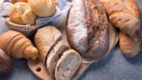 Assortment of fresh baked bread on a rustic table Stock Footage 336179650