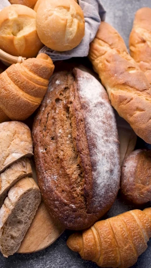 Assortment of fresh baked bread on a rustic table Stock Footage 336619865
