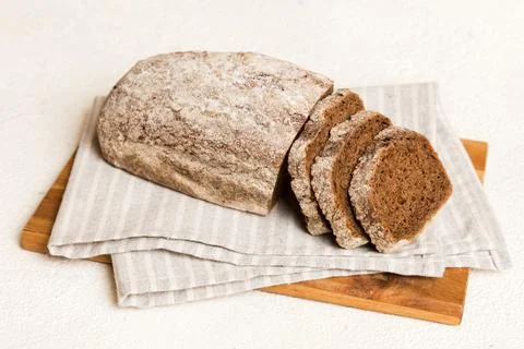 Assortment of freshly sliced baked bread with napkin on rustic table top vi.. Stock Photos