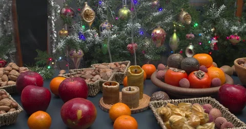 Assortment of fruits and nuts on a table with Xmas decorations behind. Stock Footage 289610283
