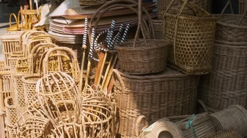 Assortment of handmade wicker baskets, straw hats and walking sticks displayed Stock Footage 315854775