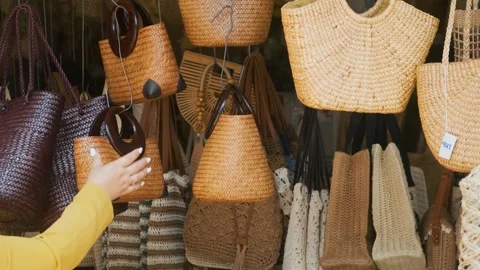 Assortment of handmade wicker baskets, straw hats and walking sticks displayed Stock Footage 315855417