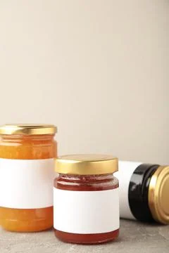 Assortment of jam jars mock-up. Jars with blank label on grey. Vertical photo Foto stock