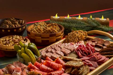 An assortment of meats, crackers, bread, nuts in wooden bowls and wooden tray wi Stock Photos