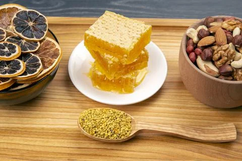 Assortment of nuts and assorted dried citrus fruits and fresh floral honeycom Stock Photos
