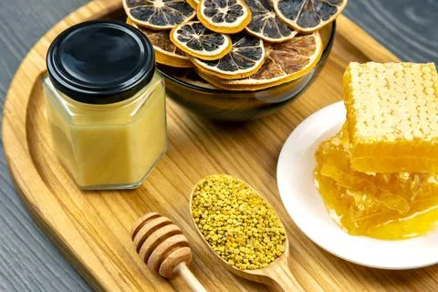 Assortment of nuts and assorted dried citrus fruits and fresh floral honeycom Stock Photos