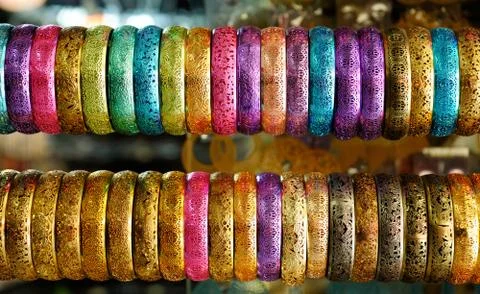 An assortment of openwork bangles painted in metallic, satureted colors hangi Stock Photos