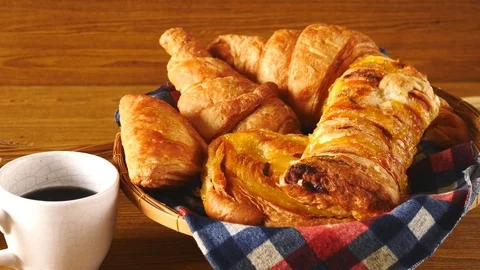 Assortment of pastries with coffee on wooden table background. Stock Footage