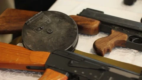 An assortment of pistols and machine guns on a table Stock Footage 71538293