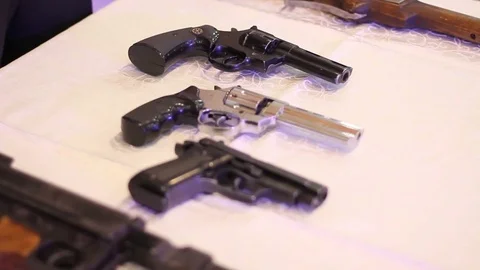 An assortment of pistols on a table Stock Footage 71529700