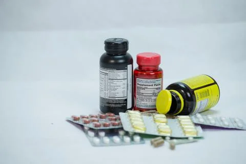 Assortment of Prescription Drug bottles with capsules poured out Stock Photos
