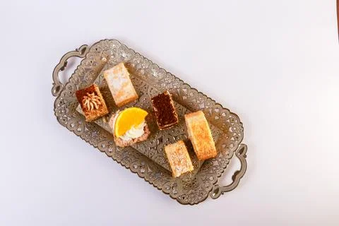 Assortment of six bite-sized cake varieties including layered sponge slices Stock Photos