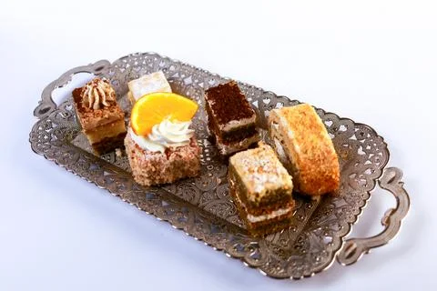 Assortment of six bite-sized cake varieties including layered sponge slices Stock Photos