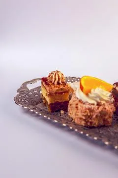 Assortment of six bite-sized cake varieties including layered sponge slices Stock Photos