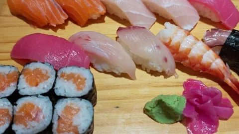 Assortment of sushi rolls and sashimi on wooden platters. Sushi rolls set served Stock Footage 336649002