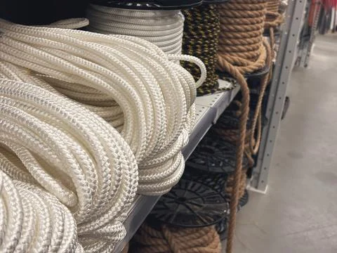 Assortment of thick structural ropes and heavy cordage on racks inside a DI.. Stock Photos