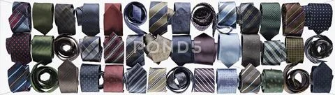 Assortment Of Ties Rolled-Up On White Background In Studio
