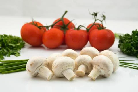 Assortment of tomatoes, mushrooms and herbs Stock Photos