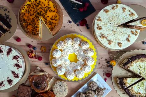 Assortment of various cakes fresh from the workshop on wooden table. Assortme Stock Photos