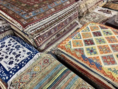 Assortment of vibrant, patterned Central Asian carpets and rugs Stock Photos