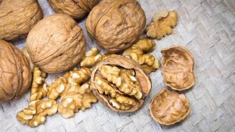 Assortment of walnut shells, walnut kernels and cracked walnut shells on light Stock Photos
