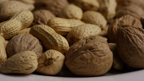 Assortment of walnuts almonds and peanuts in their shells Stock Footage 328136370