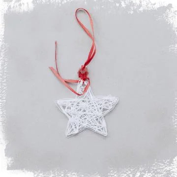 An asterisk made of white threads with a red ribbon on a light background framed Stock Photos