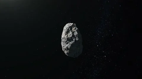 The asteroid is flying in space. Stars twinkle. The asteroid slowly rotates and Video stock 140469747