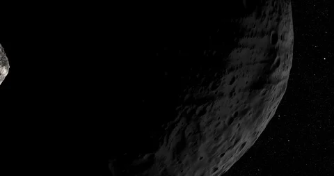 An asteroid tumbles slowly in space as it passes Vesta. Stock Footage 91709648