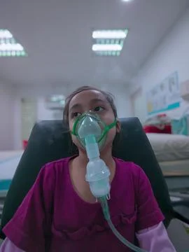 Asthma child using nebulizer in a clinic due to respiratory problem. Stock Photos