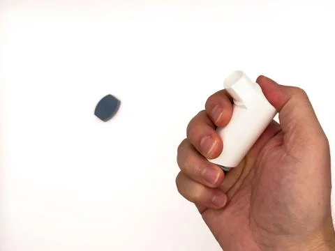Asthmatic attack. Asthma inhaler device on a white background. Breather for Stock Photos